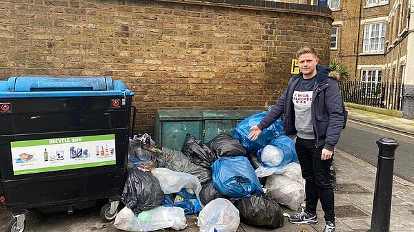 Victor Chamberlain standing in front of discarded rubbish